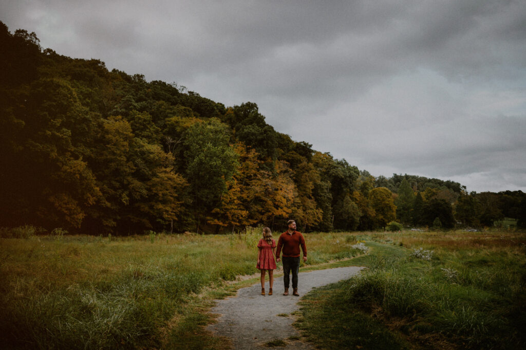 couple in the middle of a winding road in a field at natirar park