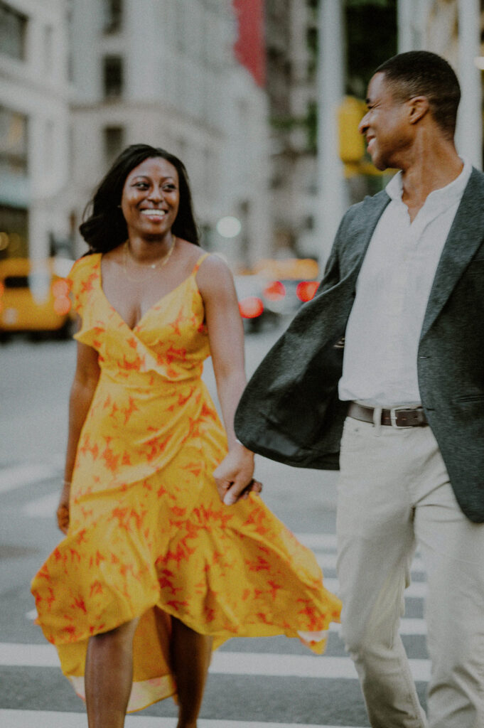 lightly guided candid engagement photo of couple crossing the street in NYC