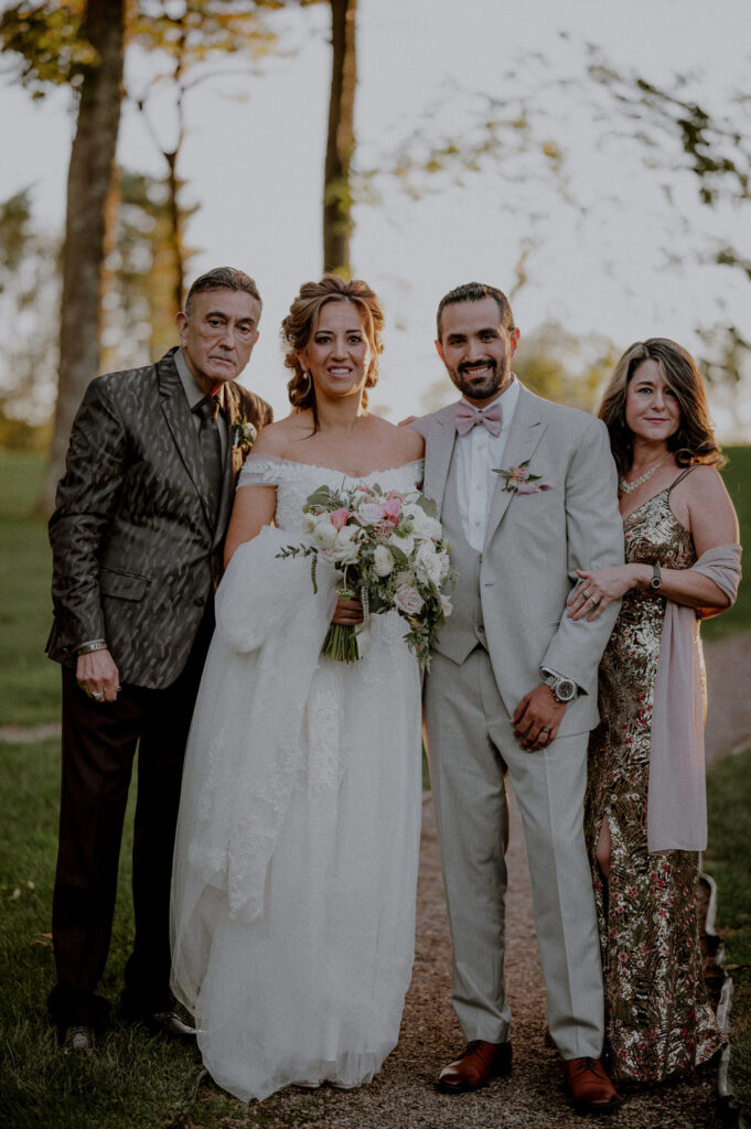 traditional style bridal portrait of bride and groom with family
