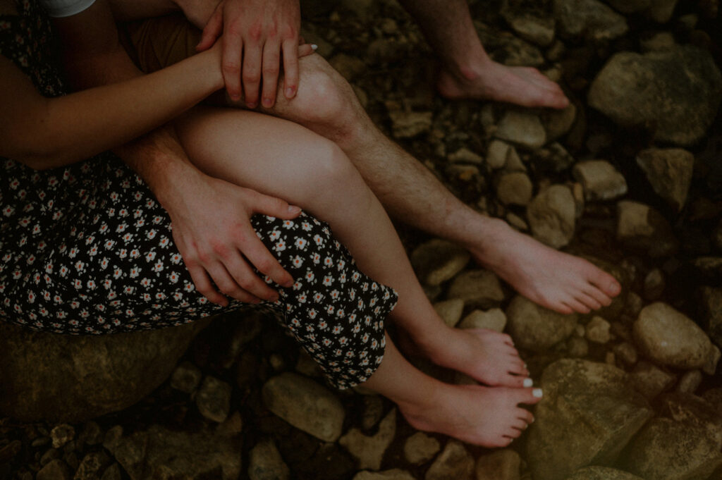 hands and bare feet of couple sitting together