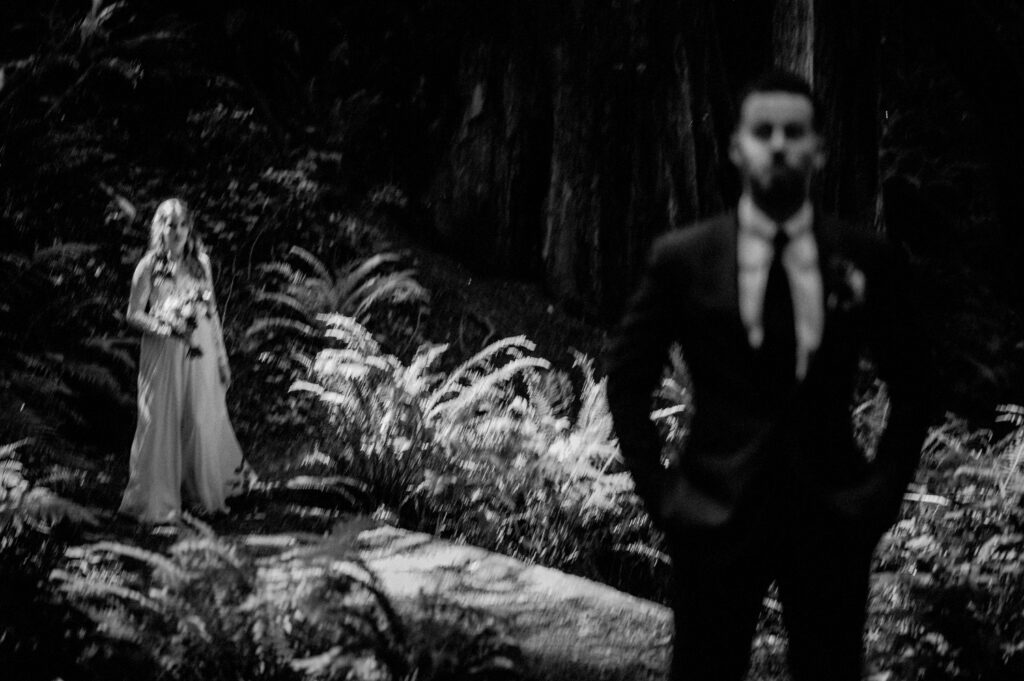 first look between a bride and groom in the forest