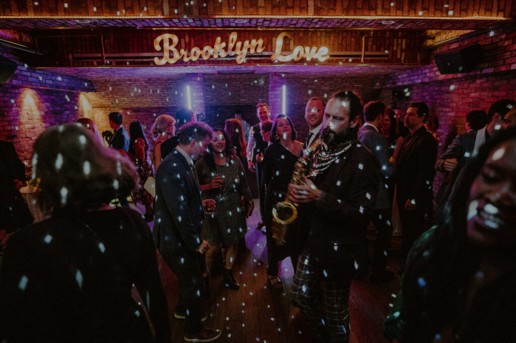 fun dance floor at wedding reception with saxophone player and laser lights