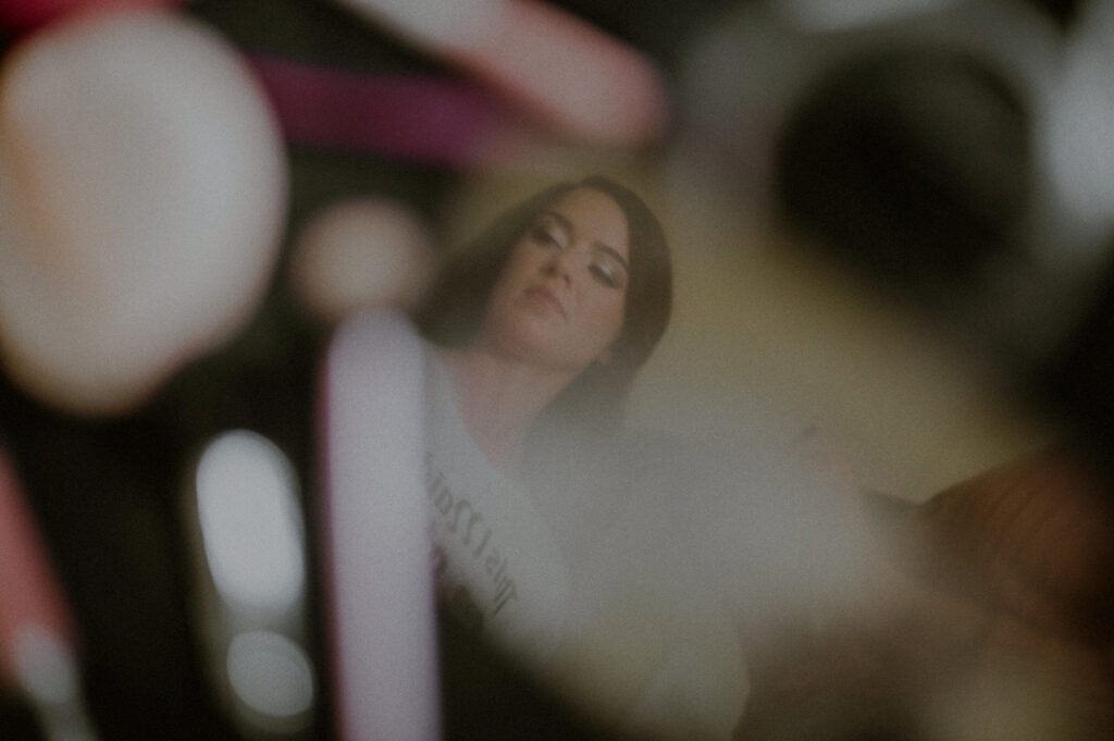 bride reflection in makeup mirror surrounded by makeup figures