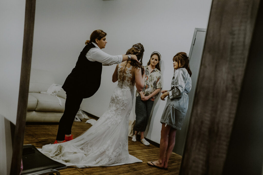 bride with mother and sister getting ready in bridal suite at factory 220