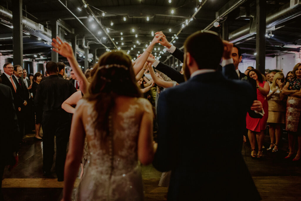 bride and groom walking into their wedding reception space