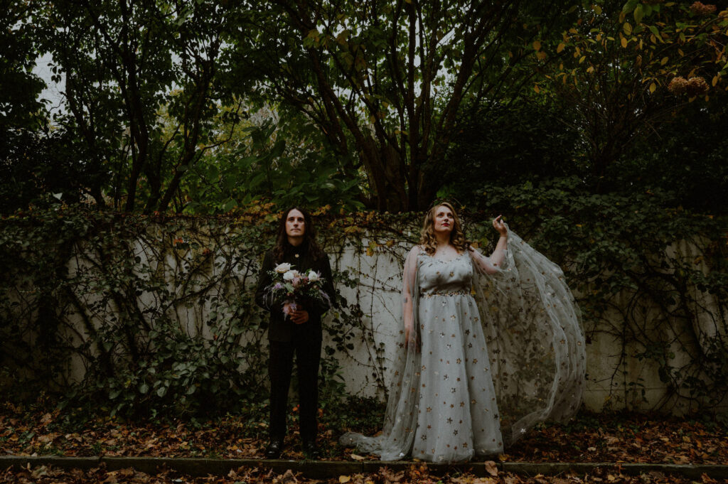 wedding couple posing in front of wall