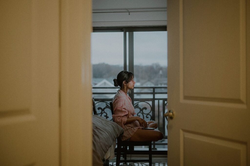 bride sitting on chair from the point of view of outside the room, framed by door