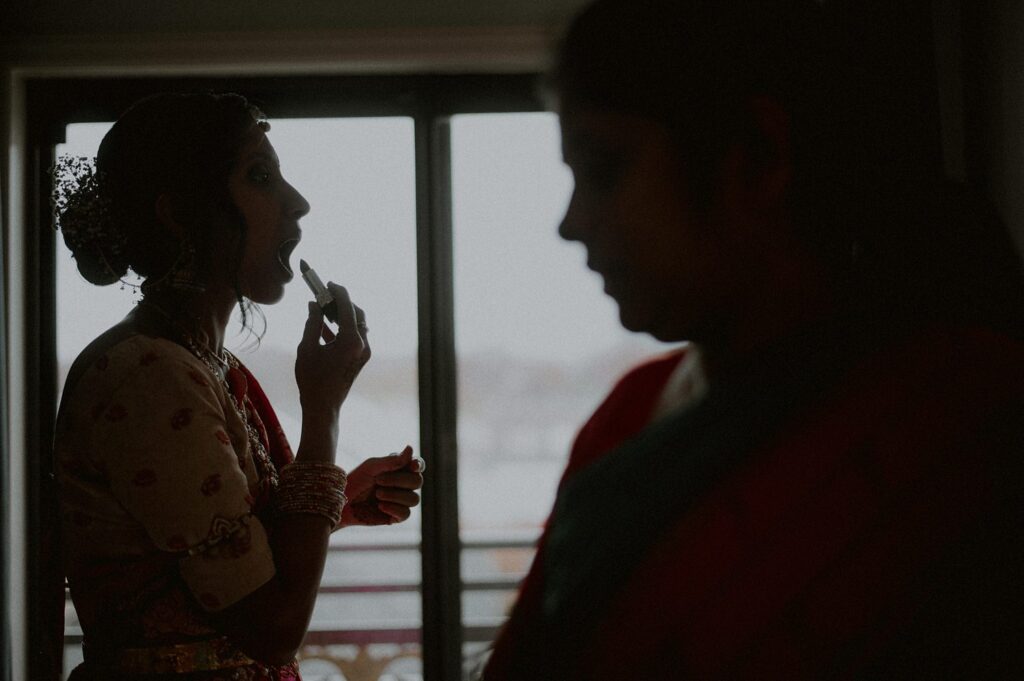 silhouette of bride putting on lipstick