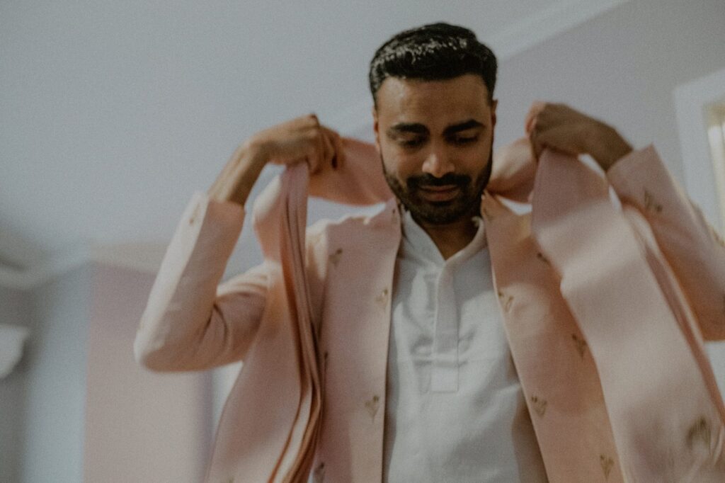 groom putting on south indian wedding attire