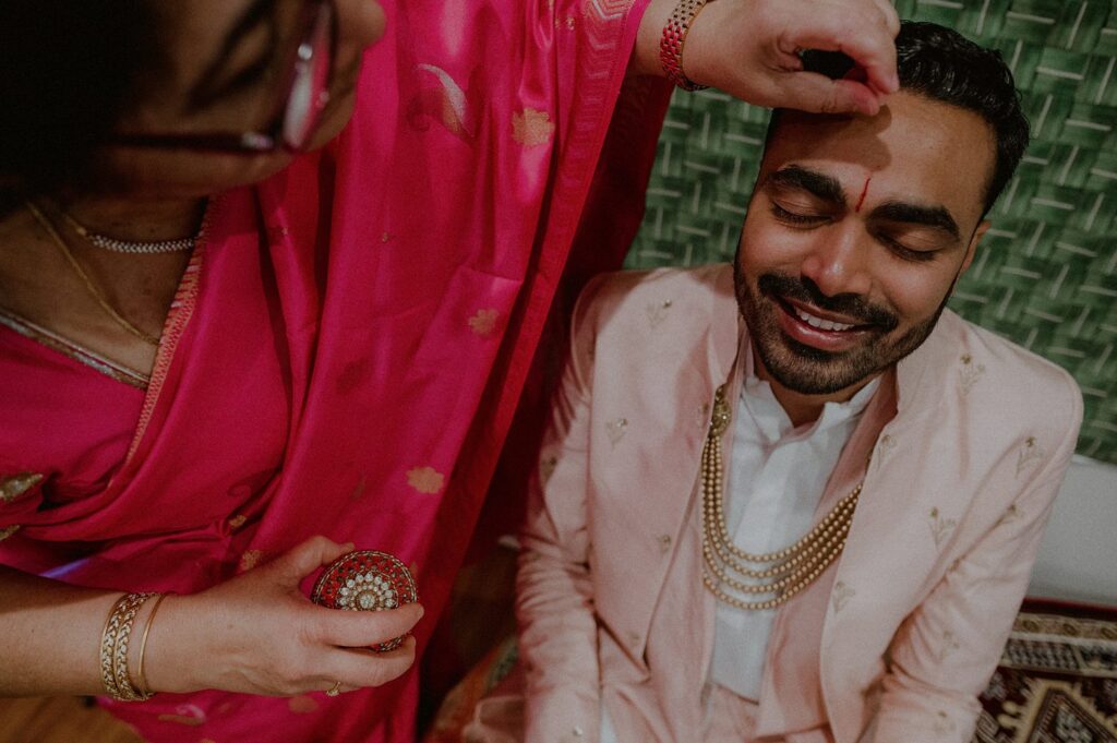 groom having bindi placed on head before indian wedding ceremony