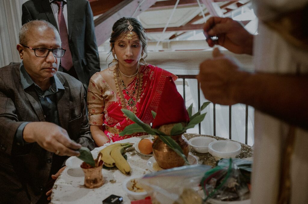 bride and father quietly sit during puja on balcony of liberty house
