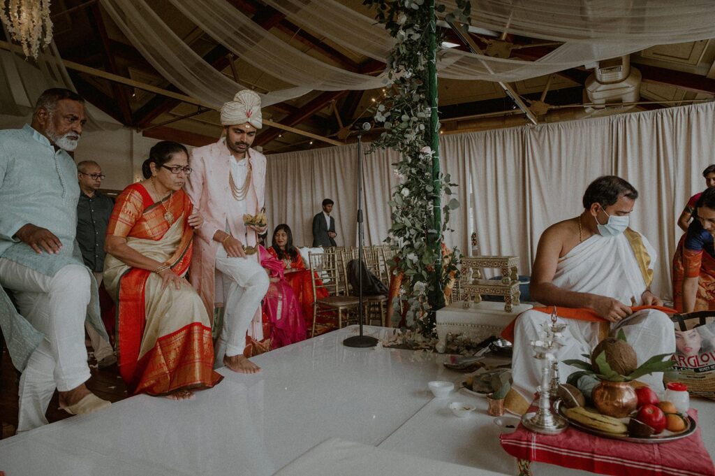 groom and parents enter mandap for puja of indian wedding ceremony