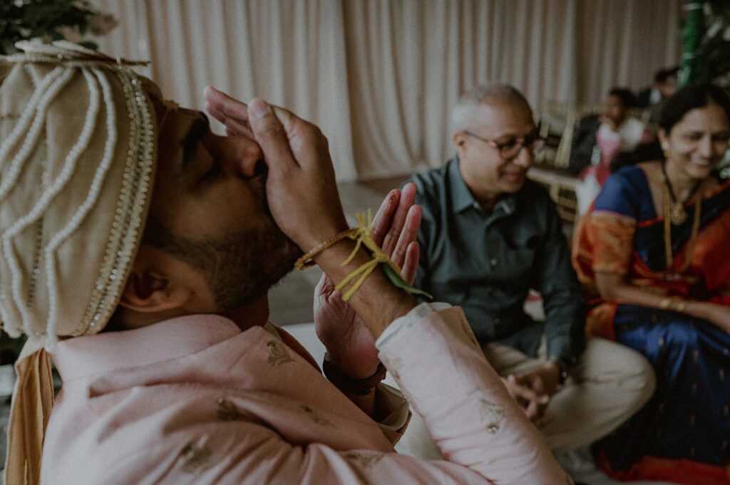 groom partaking in traditions of south indian wedding ceremony