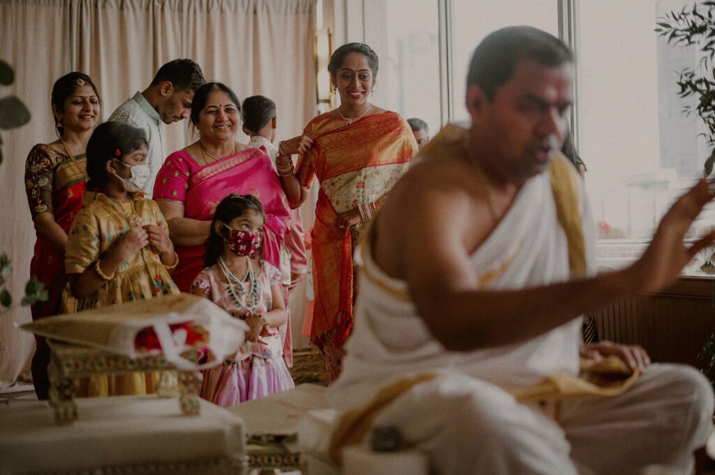 guests at indian wedding looking onto mandap and smiling