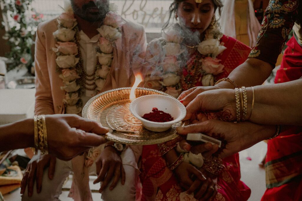 flame on tray in front of indian bride and groom