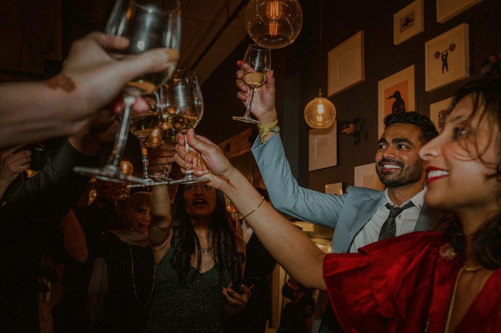 bride and groom raising glasses to group for toast