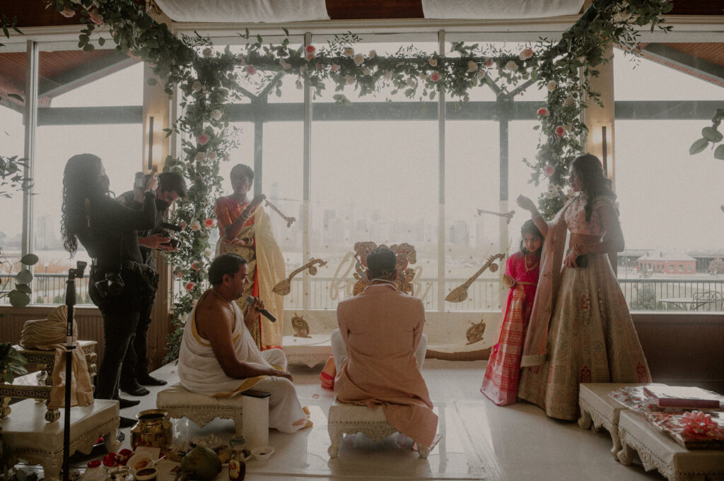 indian wedding ceremony indoors at liberty house restaurant with floor-to-ceiling windows and view of nyc skyline