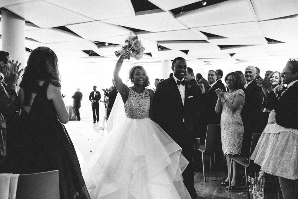 black and white documentary style photo of bride and groom joyfully exiting ceremony at maritime parc