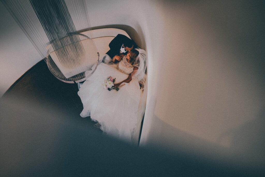 birdseye view creative portrait of bride and groom sitting on couch from above