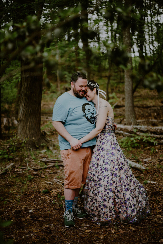 alternatively dressed wedding couple embracing in forest