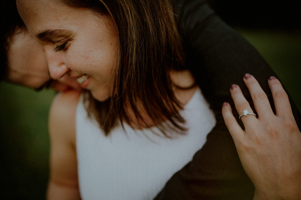 couple embracing with woman holding onto man's arm and looking away