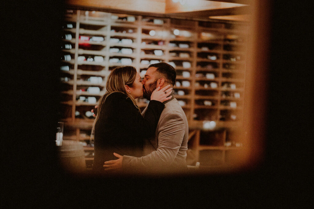 man and woman embracing and kissing at private restaurant after their engagement