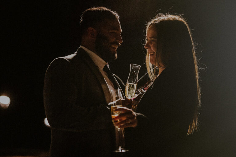 man and woman's portrait with champagne at night