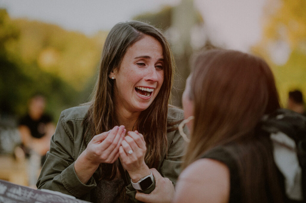 girl in excited expression showing off ring to a friend