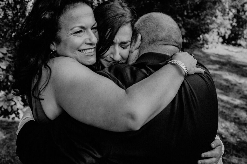 mother and father embrace daughter emotionally after elopement ceremony