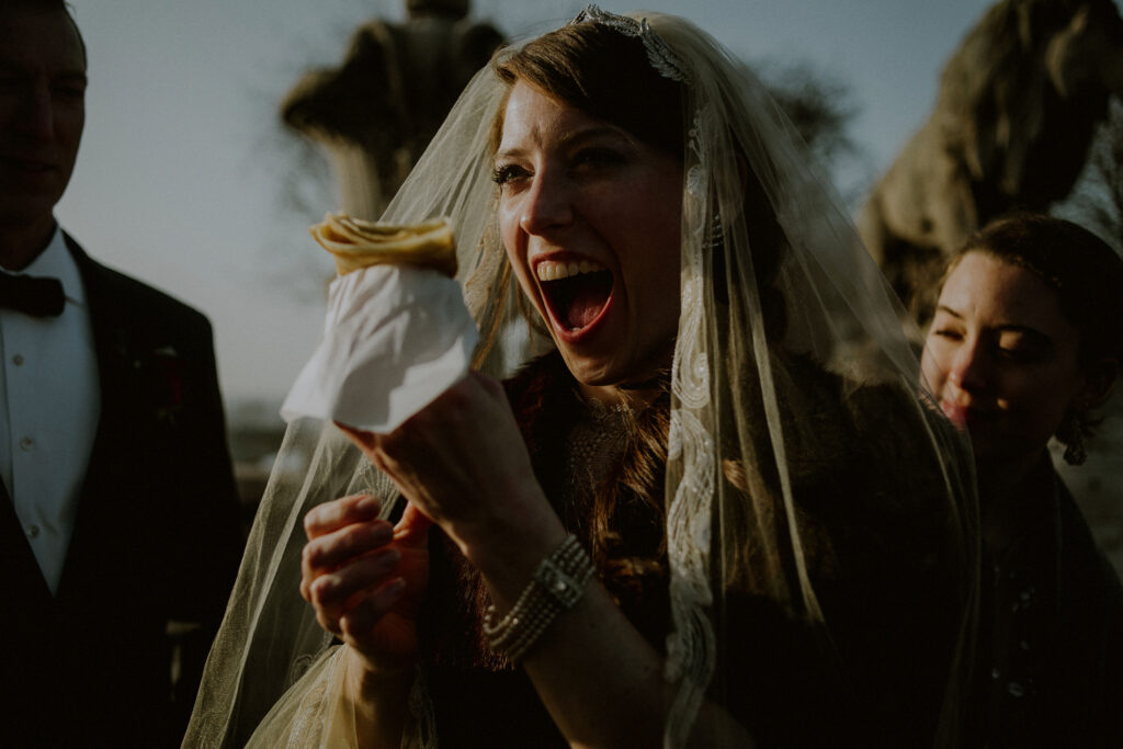 bride wearing veil joyfully holds crepe in winter paris elopement