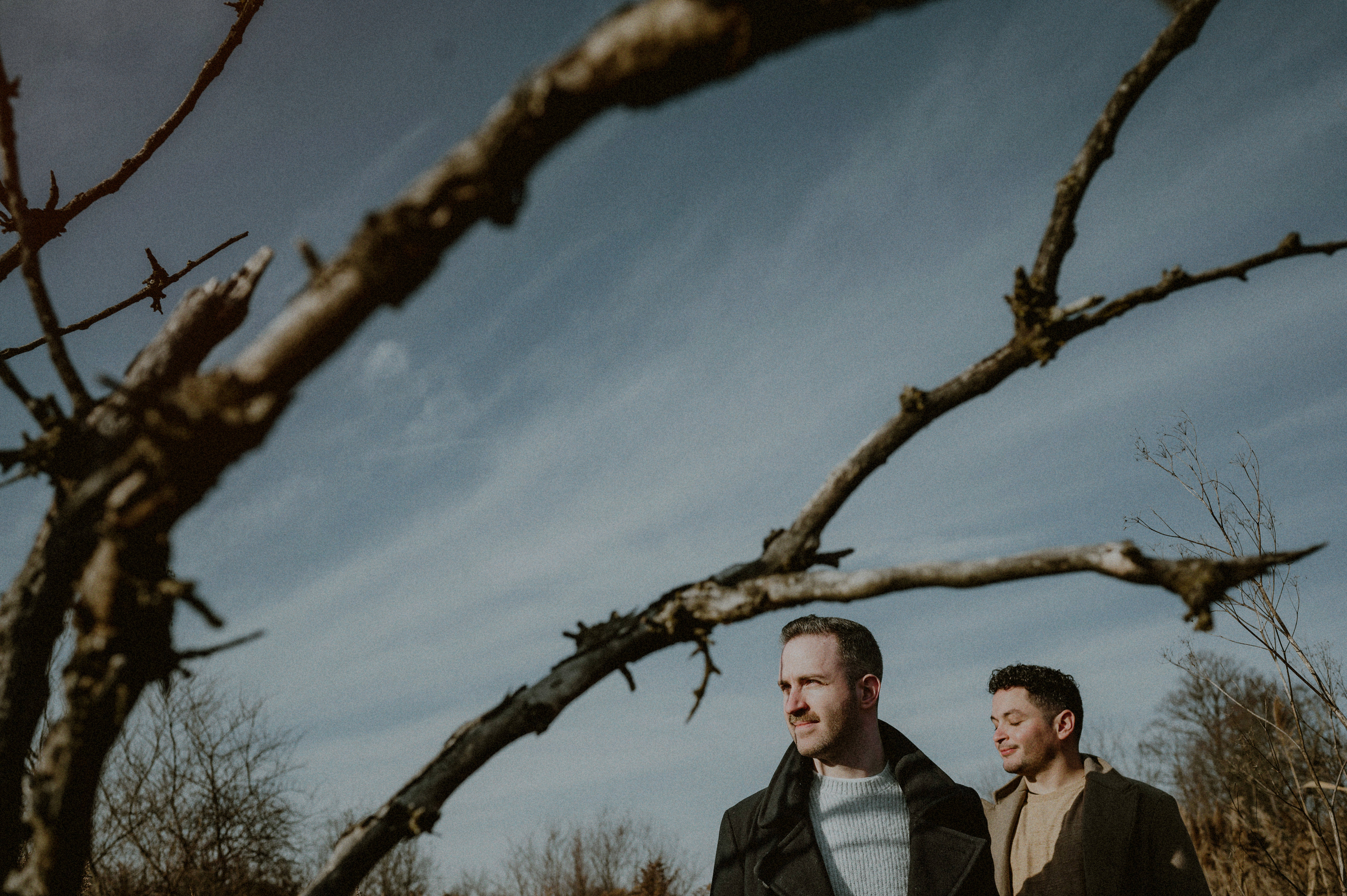 creative photo of same sex couple looking off in nj engagement session