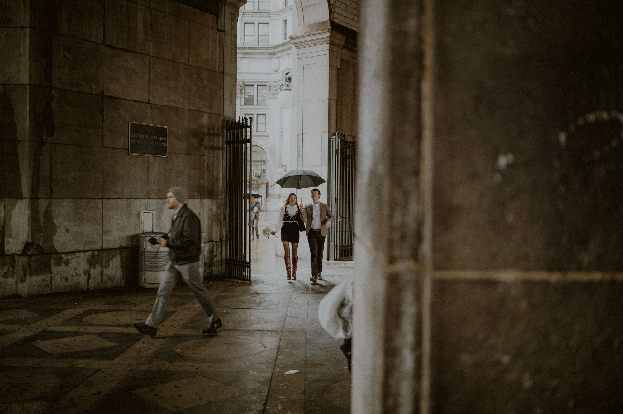 couple walking towards city hall elopement in rain