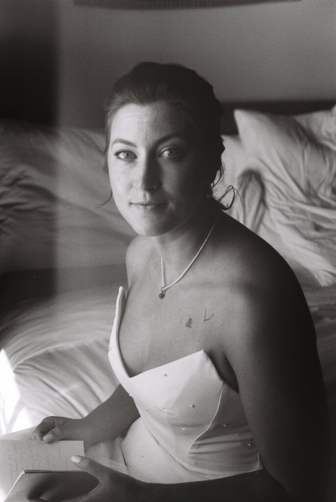 Black And White Vintage Film Photo Of Bride Sitting On Bed Pre Wedding In Nyc Hotel