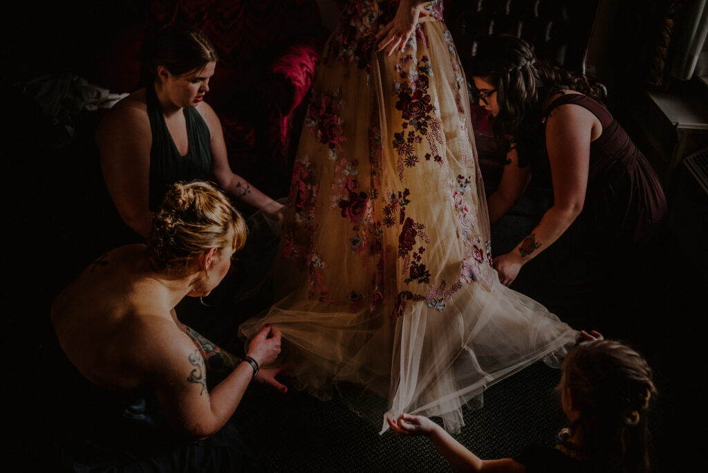 Bridal Party Arranging Bride Dress Dramatic Photo