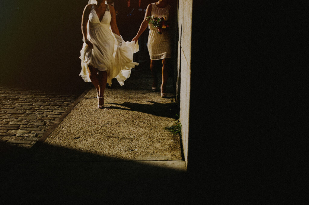 Bride Bridesmaid Walking Through Sunlight Brooklyn Wedding