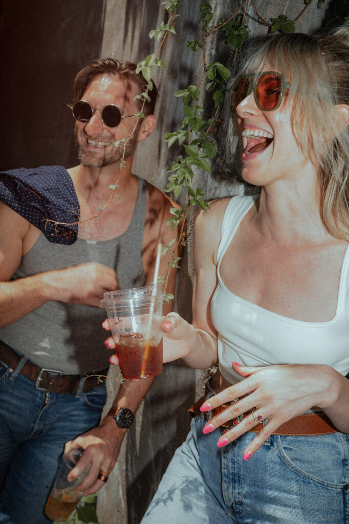 Casual Couple Candidly Laughing At Summertime Engagement Session
