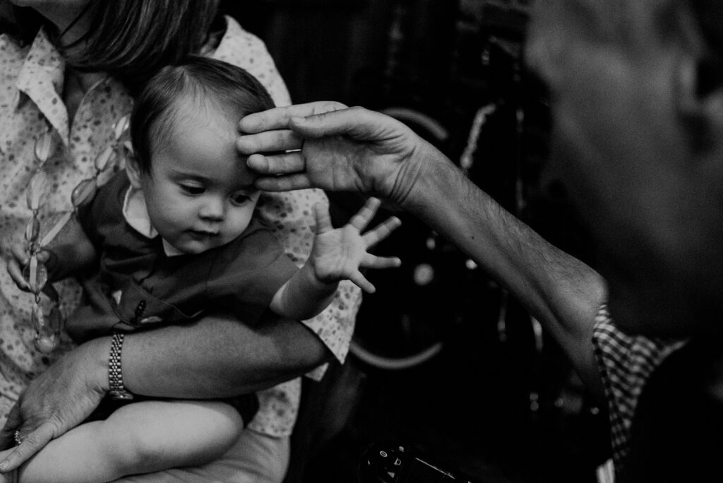 Tender Moment Between Grandfather Hands And Baby During Family Shoot